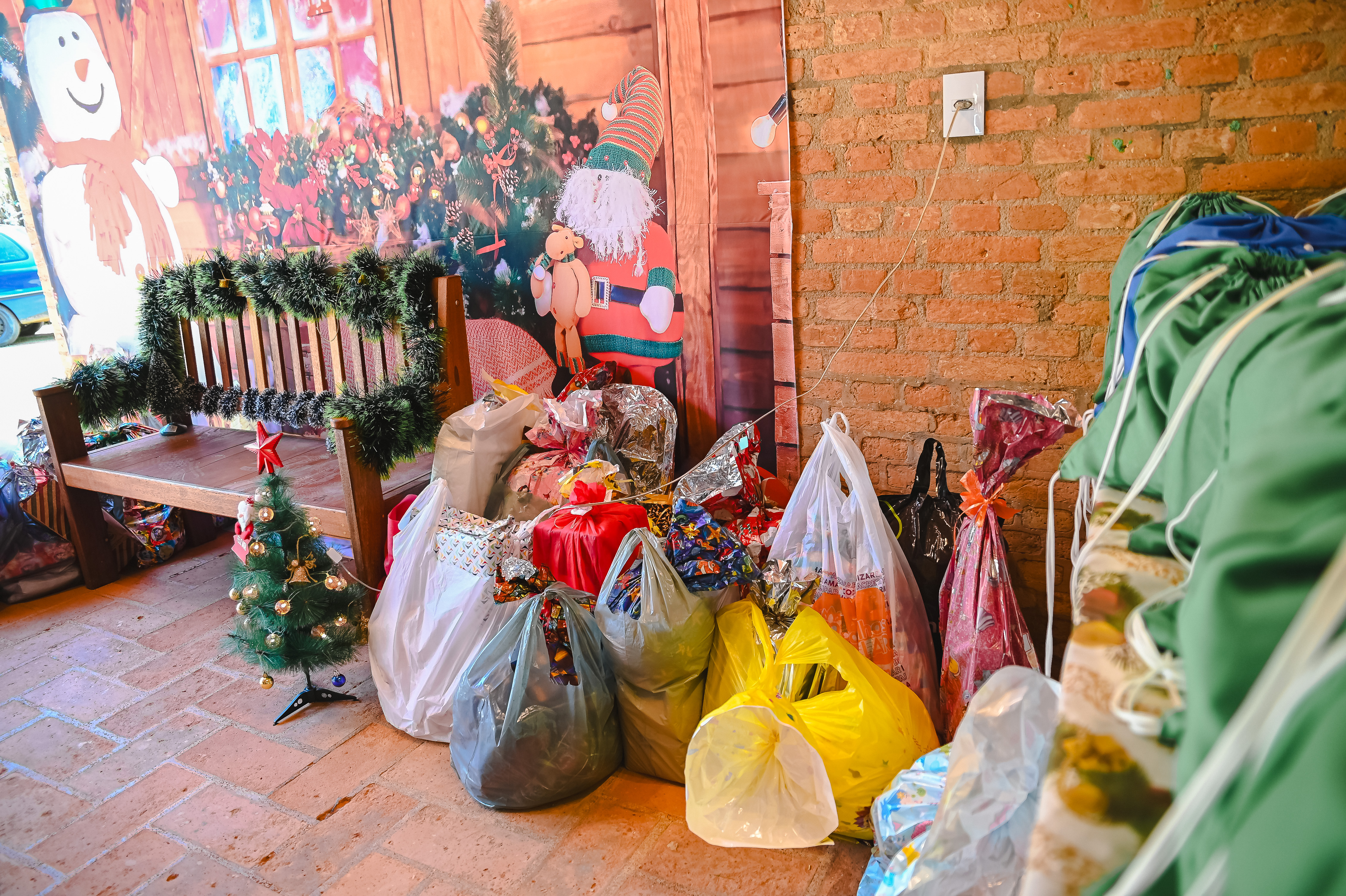 Mesa repleta de presentes para distribuição no Natal